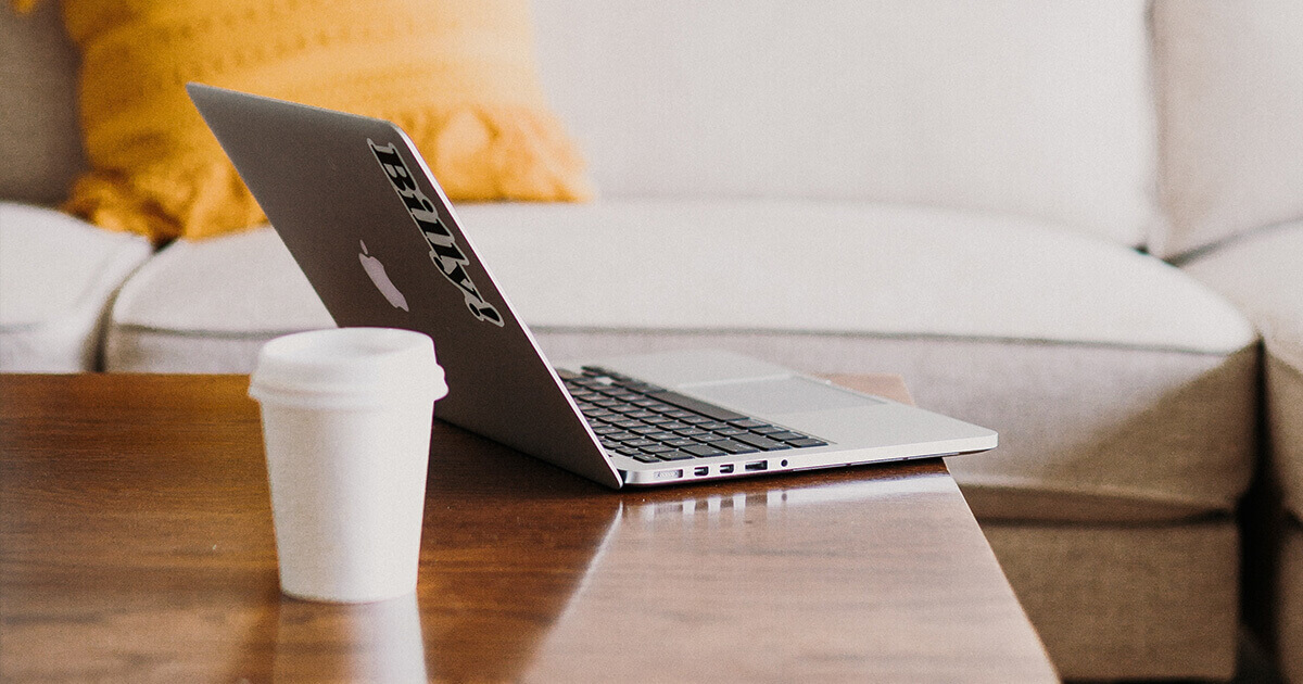 Laptop and coffee cup on a wooden table. Remote work, work from home, career opportunities.