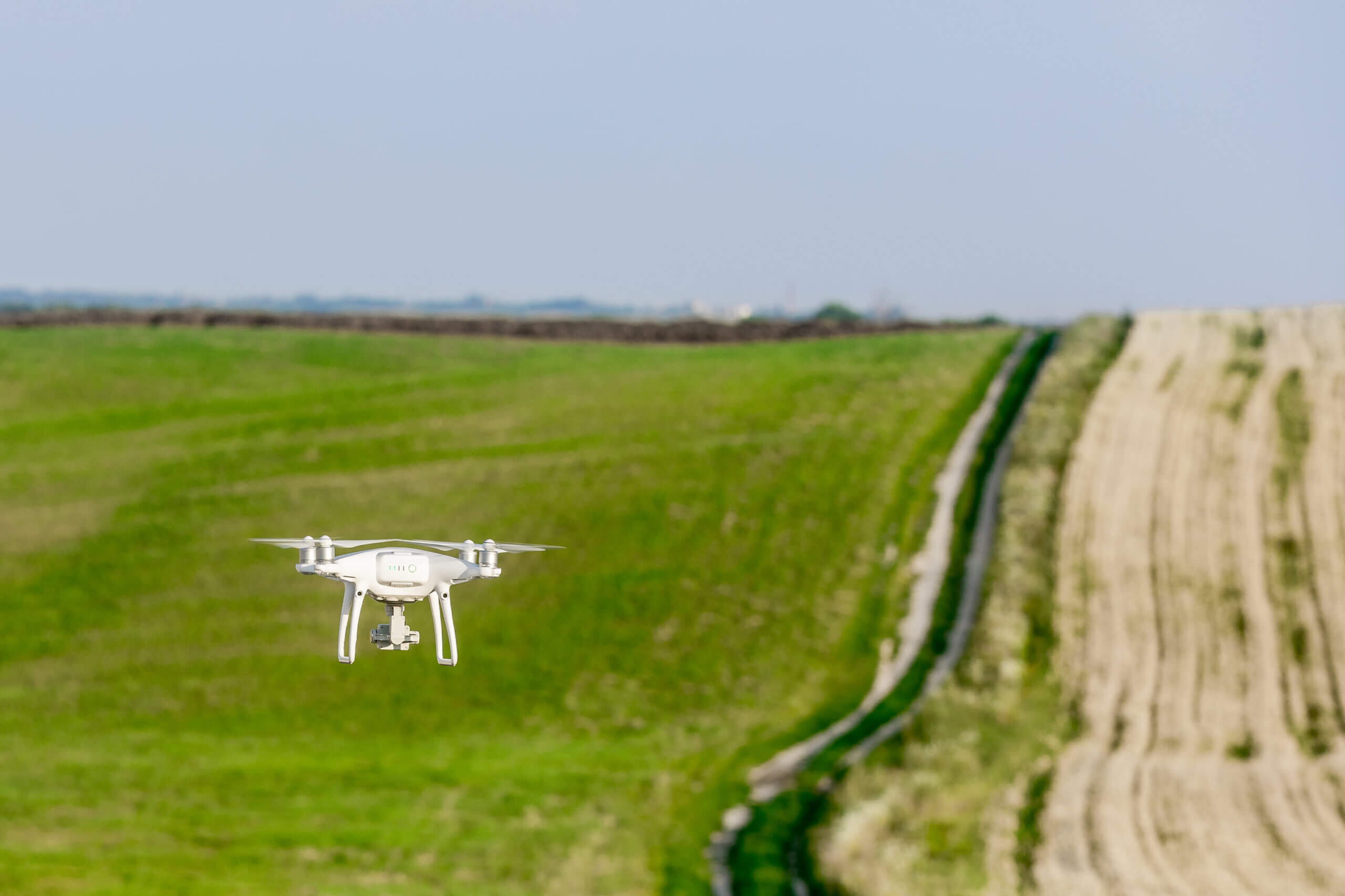 Intelinair drone delivering same-day crop intelligence with MASV. Aerial view of drone over green fields. Technology in agriculture.